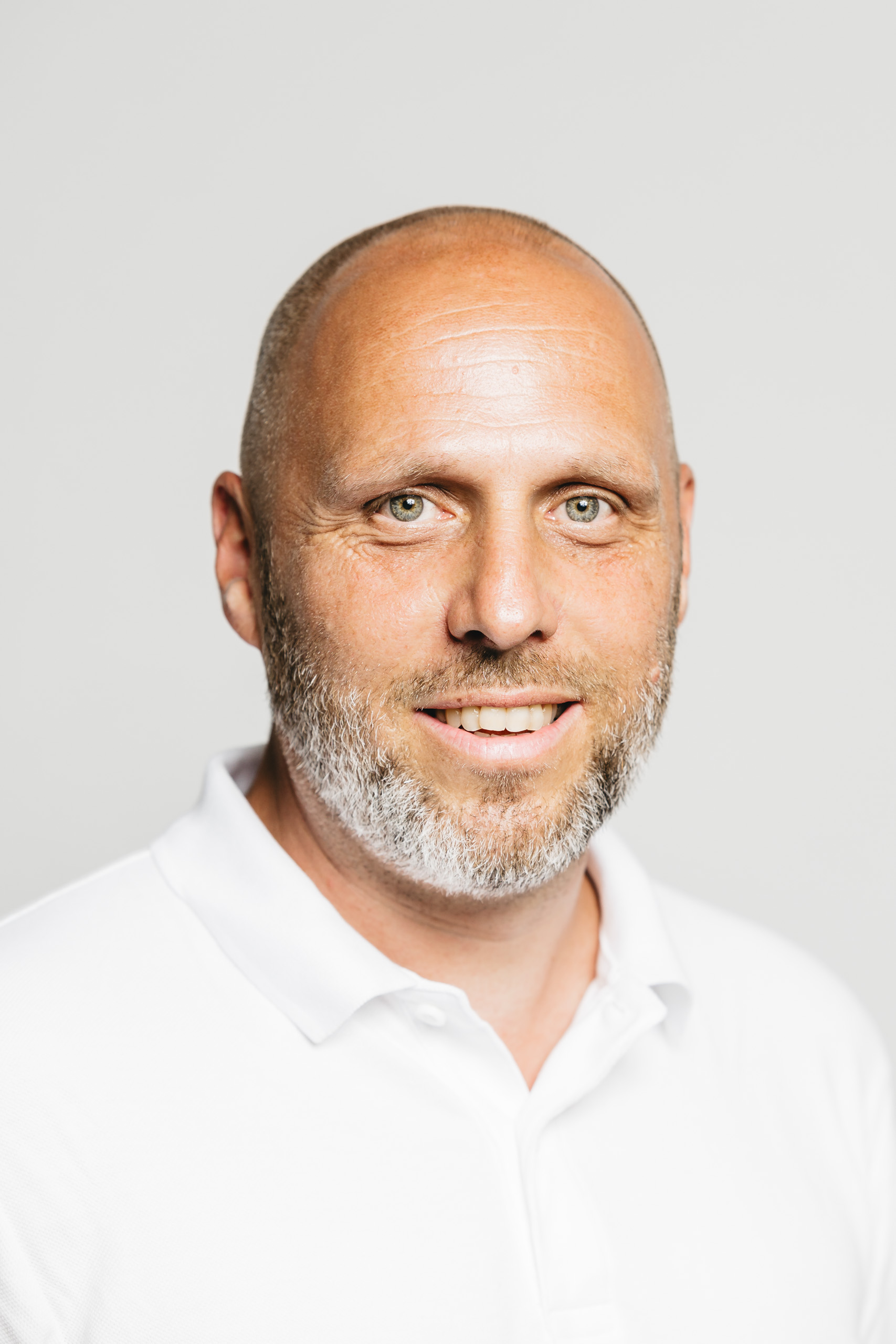 Portrait Florian Prinz in weißem Polohemd.